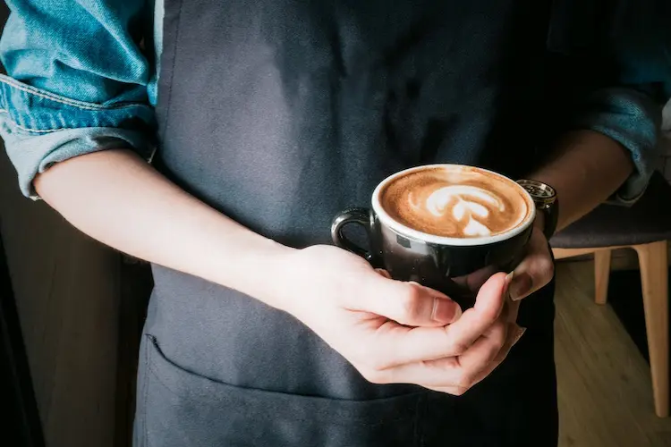 a-person-holding-a-mug-of-cappuccino
